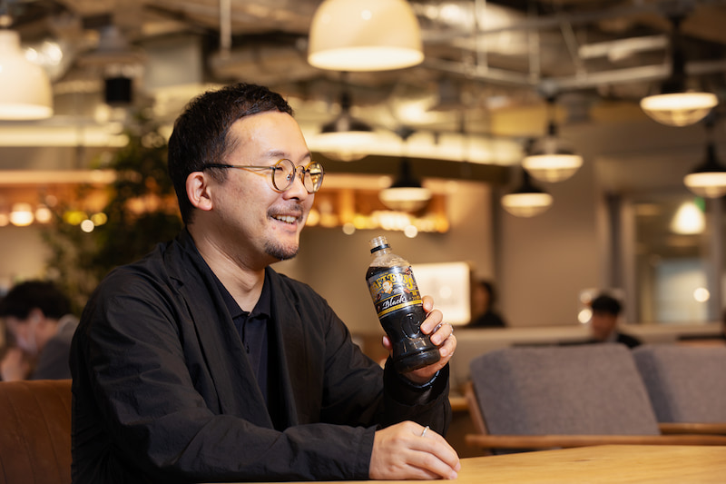 Marketing Nativeのインタビューを受けるサントリービバレッジ＆フード 新価値創造部長 大塚匠さんの写真。左手にクラフトボスを持っている。